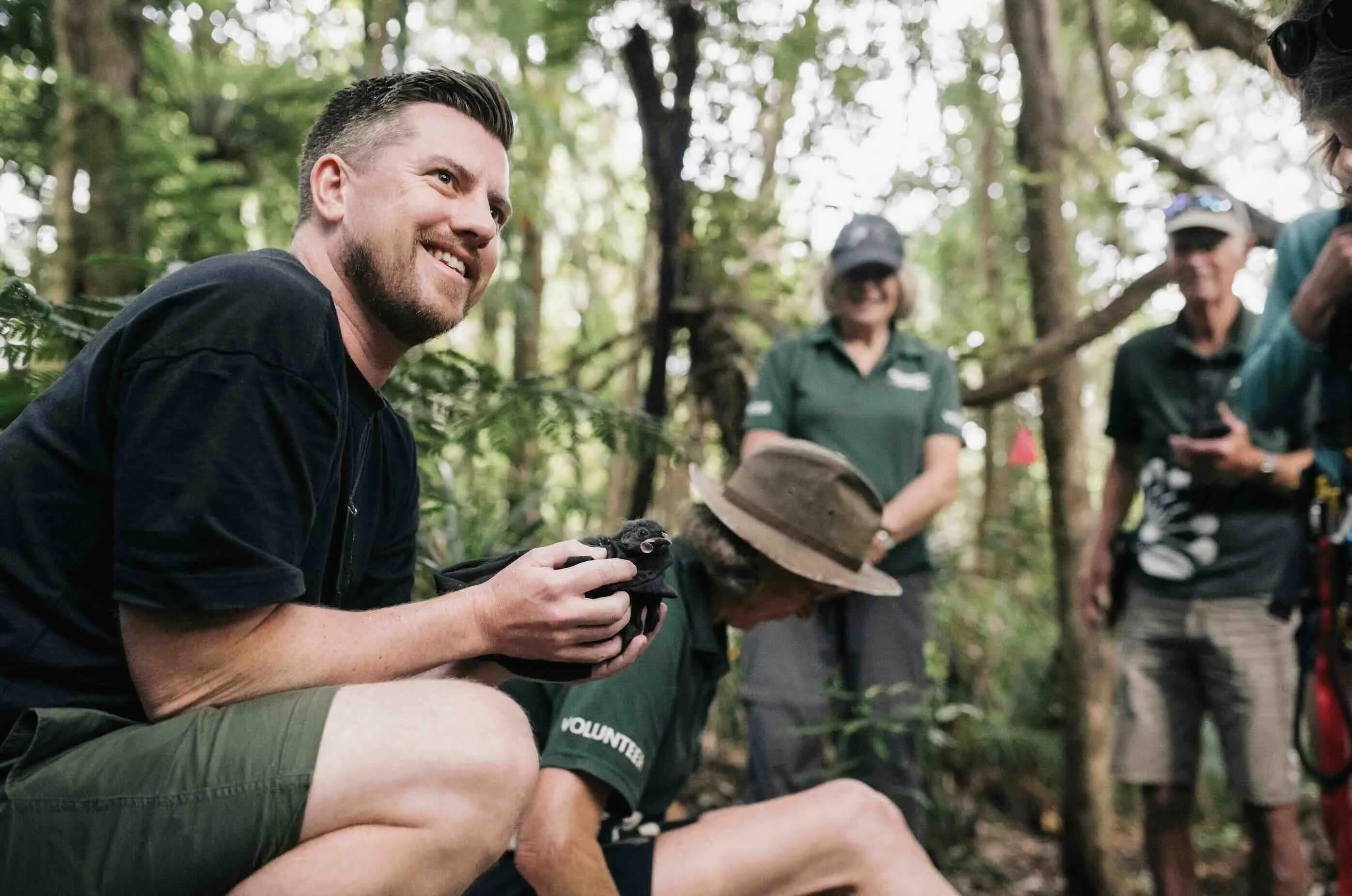 Richard holding a bird in a forest